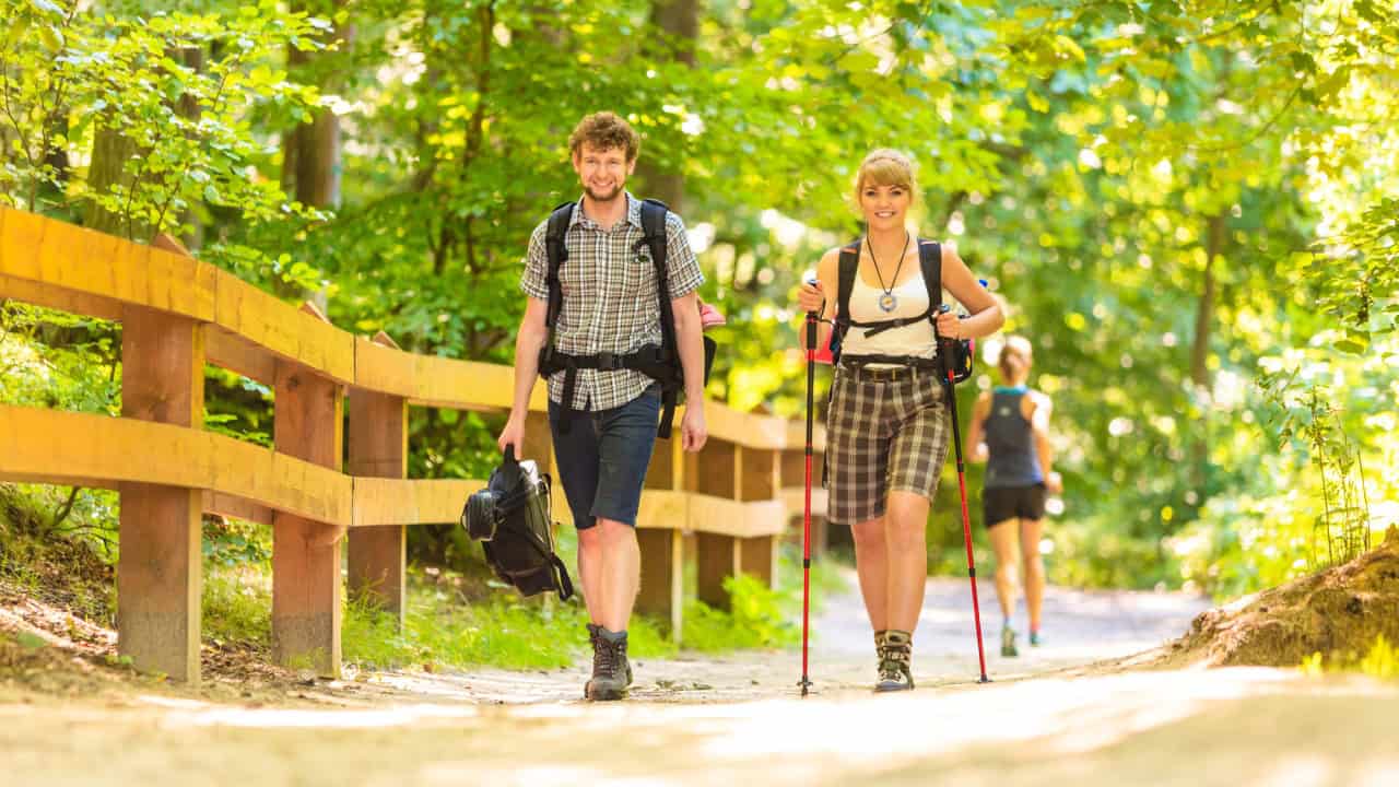 Couple backpacker hiking in forest pathway