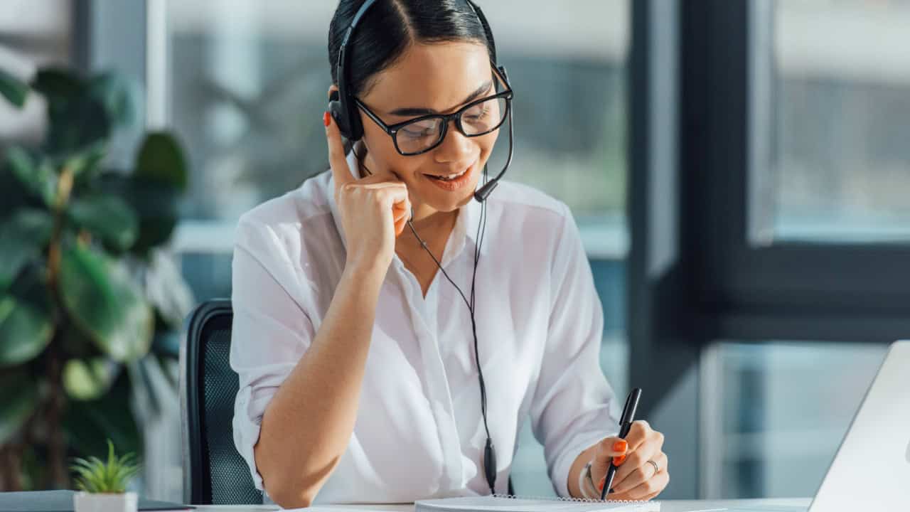 Smiling asian translator working online with headset