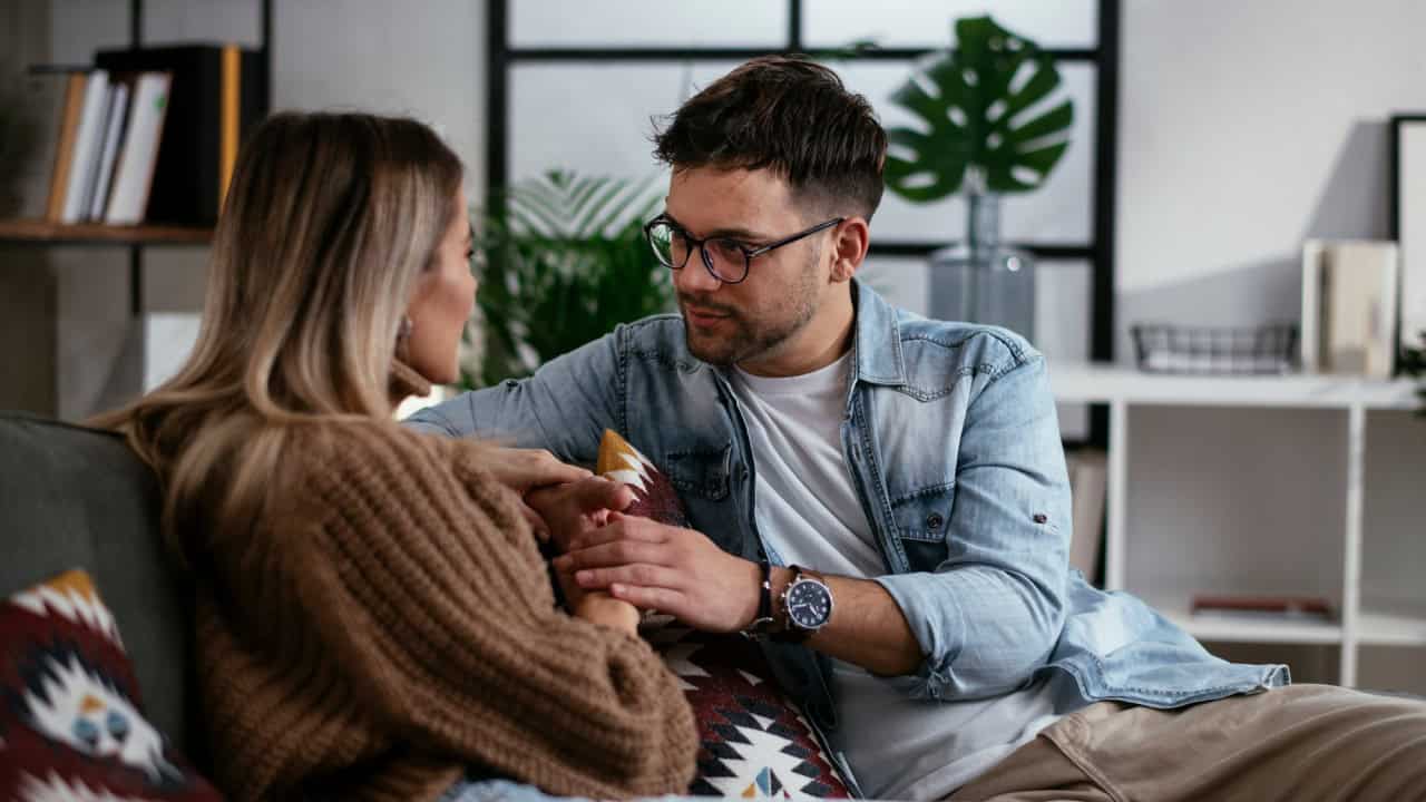 Young couple sitting and talking at home