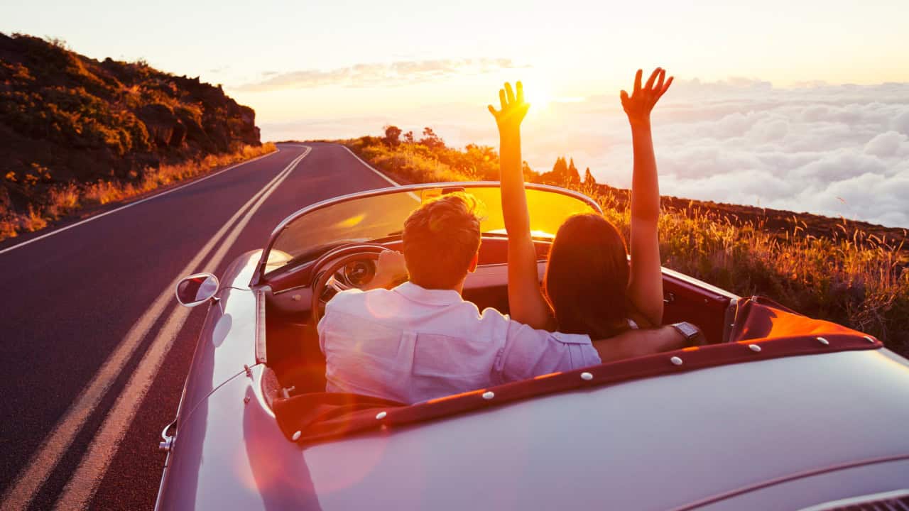 Romantic Couple Driving on Beautiful Road at Sunset