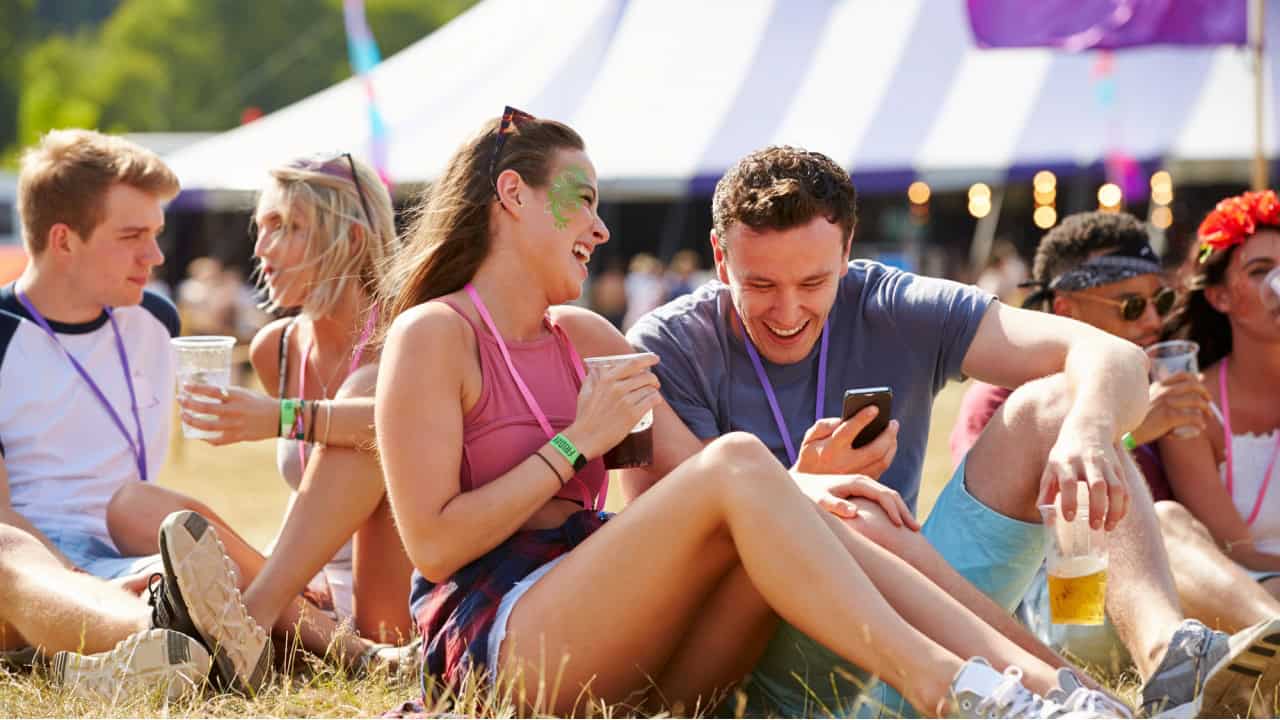 Friends using smartphone at music festival