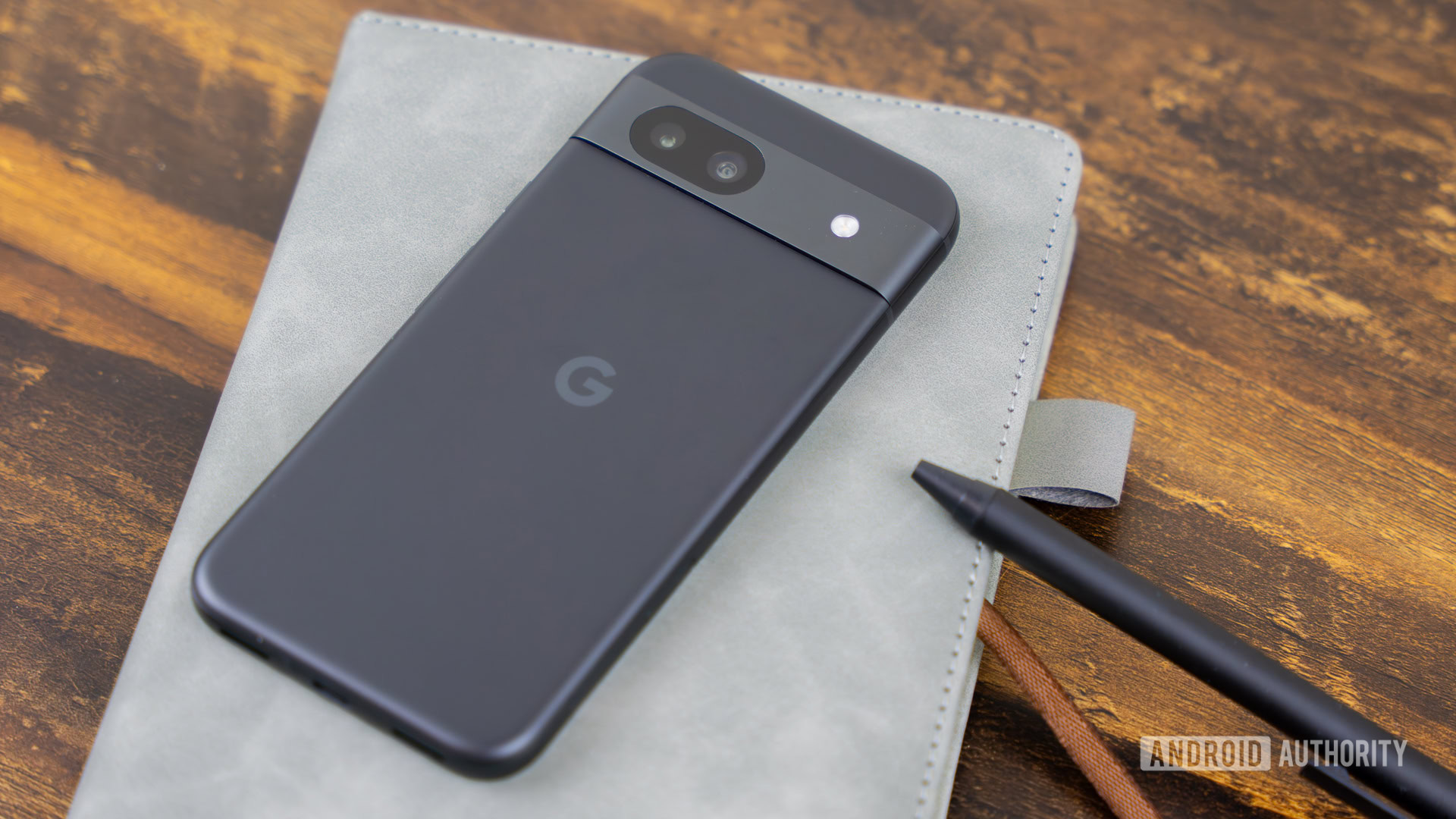 Google Pixel 8a laying on top of notebook stock photo (1)