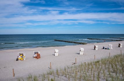 Blick über einen hellen Sandstrand mit wenigen Strandkörben an der Ostsee in Mecklenburg-Vorpommern.