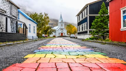 Ein echter Hingucker sind der Regenbogenweg und die weiße Kirche in Seydisfjördur.