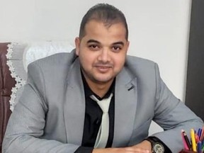 Journalist Abdallah Aljamal, who was killed after IDF raided his home to rescue three Israeli hostages, sitting at desk.