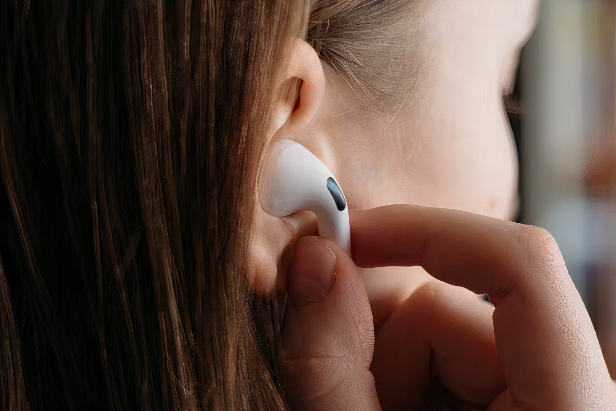 Woman putting AirPods Pro in ear.