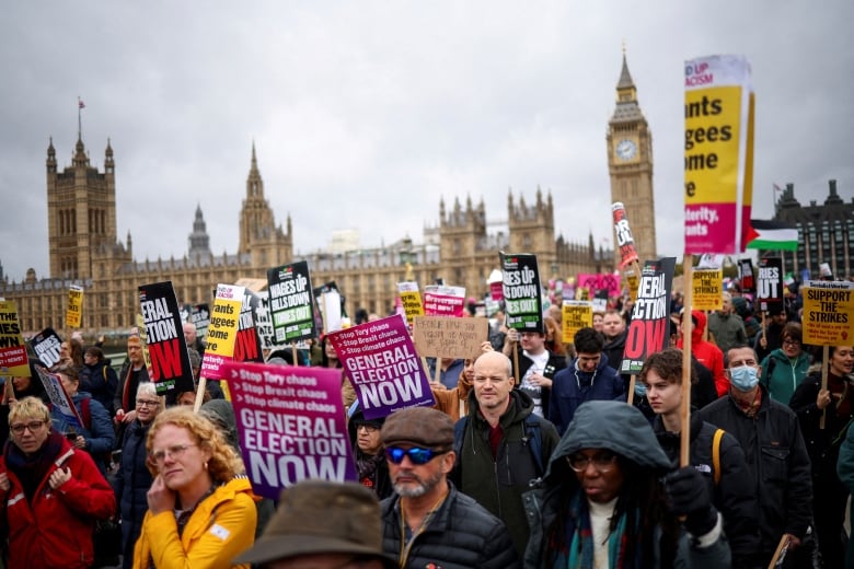 Protesters hold signs in London.