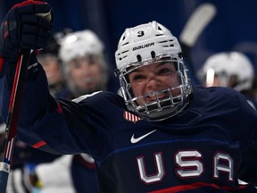 Cayla Barnes smiles while skating past the bench in a Team USA uniform