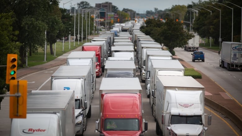 A three-lane roadway completely blocked with tractor trailers.