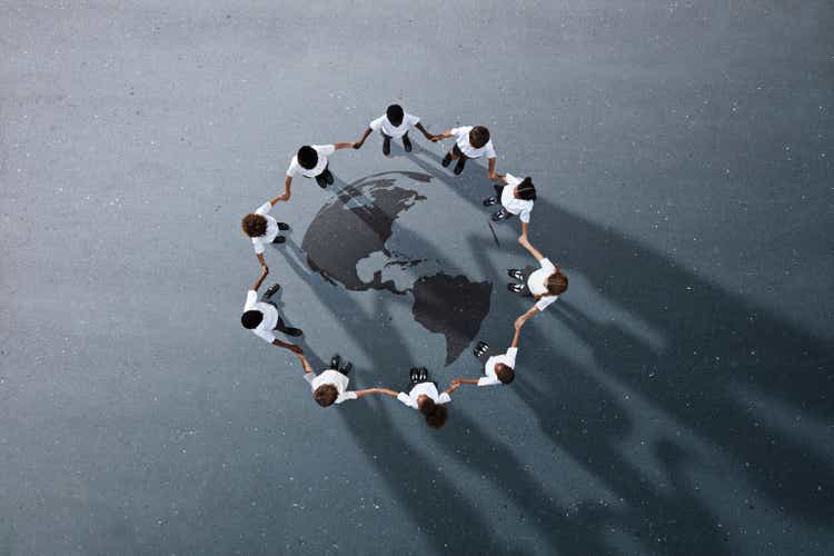 School children in uniforms standing in circle & holding hands