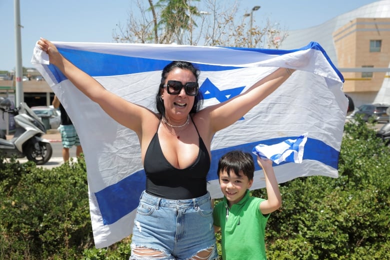 A woman holds an Israeli flag.