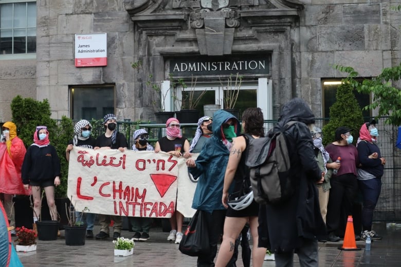 protesters carry a banner saying "l'chaim intifada"