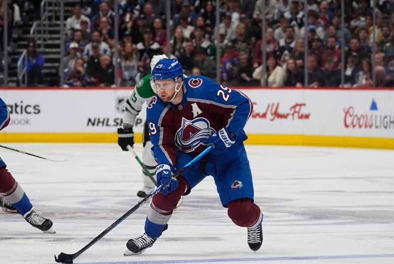 A male hockey player is seen mid-game.