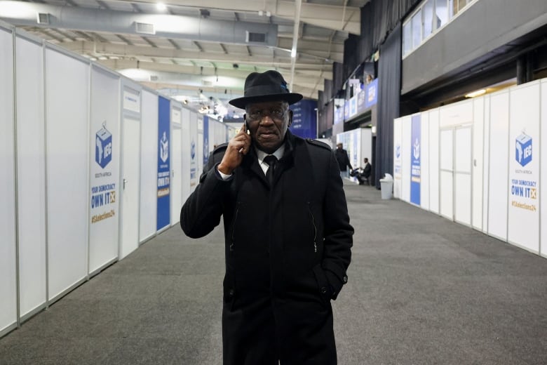 A man in a hat listens to his phone.