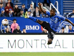 CF Montréal forward Kwadwo Opoku, in blue jersey and black shorts, jumps in the air with his right leg outstretched for the ball.