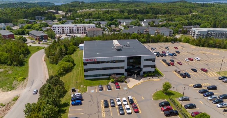 A square building and parking lot seen from the air.